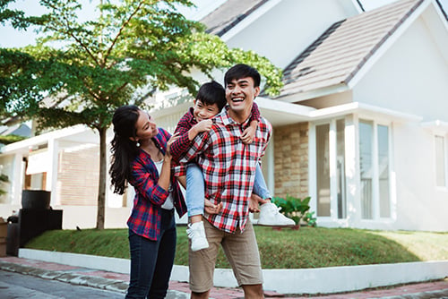 shortly after refinancing a mortgage with Gate City Bank, a happy father carries his son on his back while his wife follows