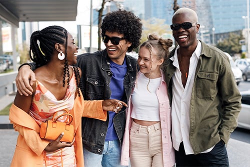 Four Gen Z friends walking down the sidewalk in downtown St. Cloud, Minnesota