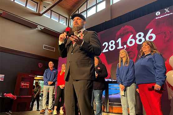 Christopher Johnson, CEO of Rape and Abuse Crisis Center in Fargo-Moorhead, speaks onstage during Giving Hearts Day 2024