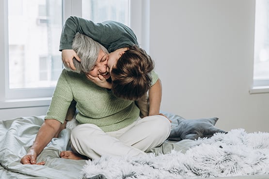 : a grandson kisses his grandma’s cheek after she learned tips to boost retirement savings from Gate City Investment Services