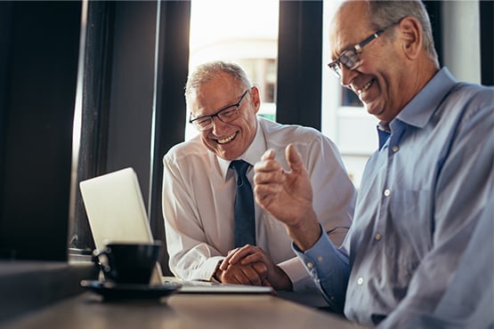 Financial advisor at Gate City Investment Services in Fargo, ND, smiling and sitting beside a client nearing retirement age