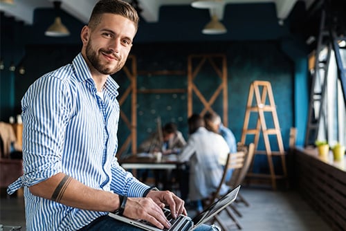 Young man in button-down striped shirt, browsing wealth management resources on the Gate City website