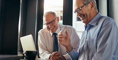 Financial advisor at Gate City Investment Services in Fargo, ND, smiling and sitting beside a client nearing retirement age
