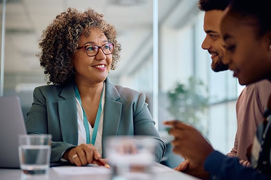 a happy lender sits down to provide solutions and answer her customers’ questions about their Gate City Bank personal loan