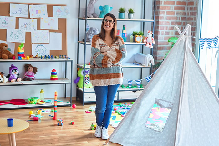 A happy daycare owner stands in an updated play area made possible with Gate City Bank’s BetterLife™ Child Care Business Loan