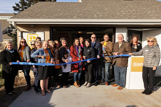 happy group cuts ribbon with scissors for West Fargo Eats ceremony
